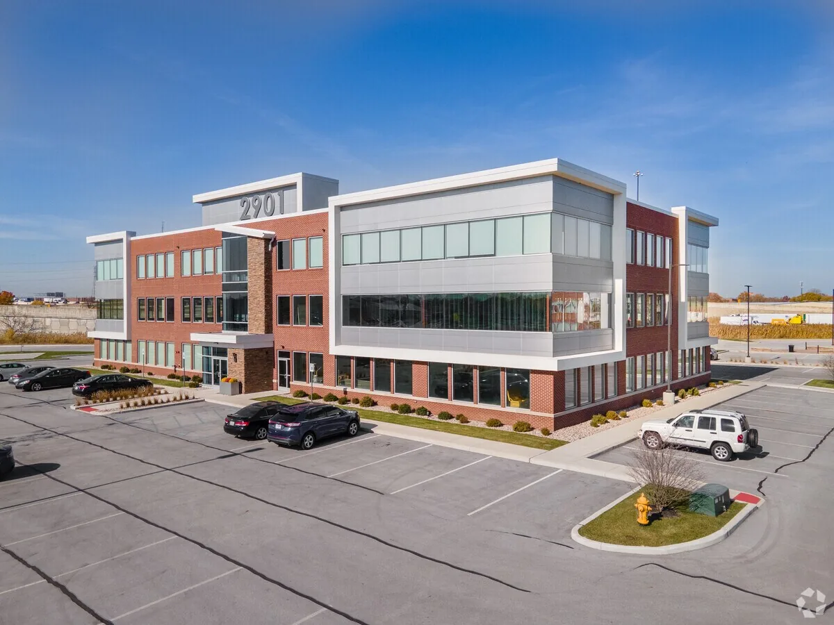 Modern three-story commercial building with red brick and white metal panels at 2901 address.